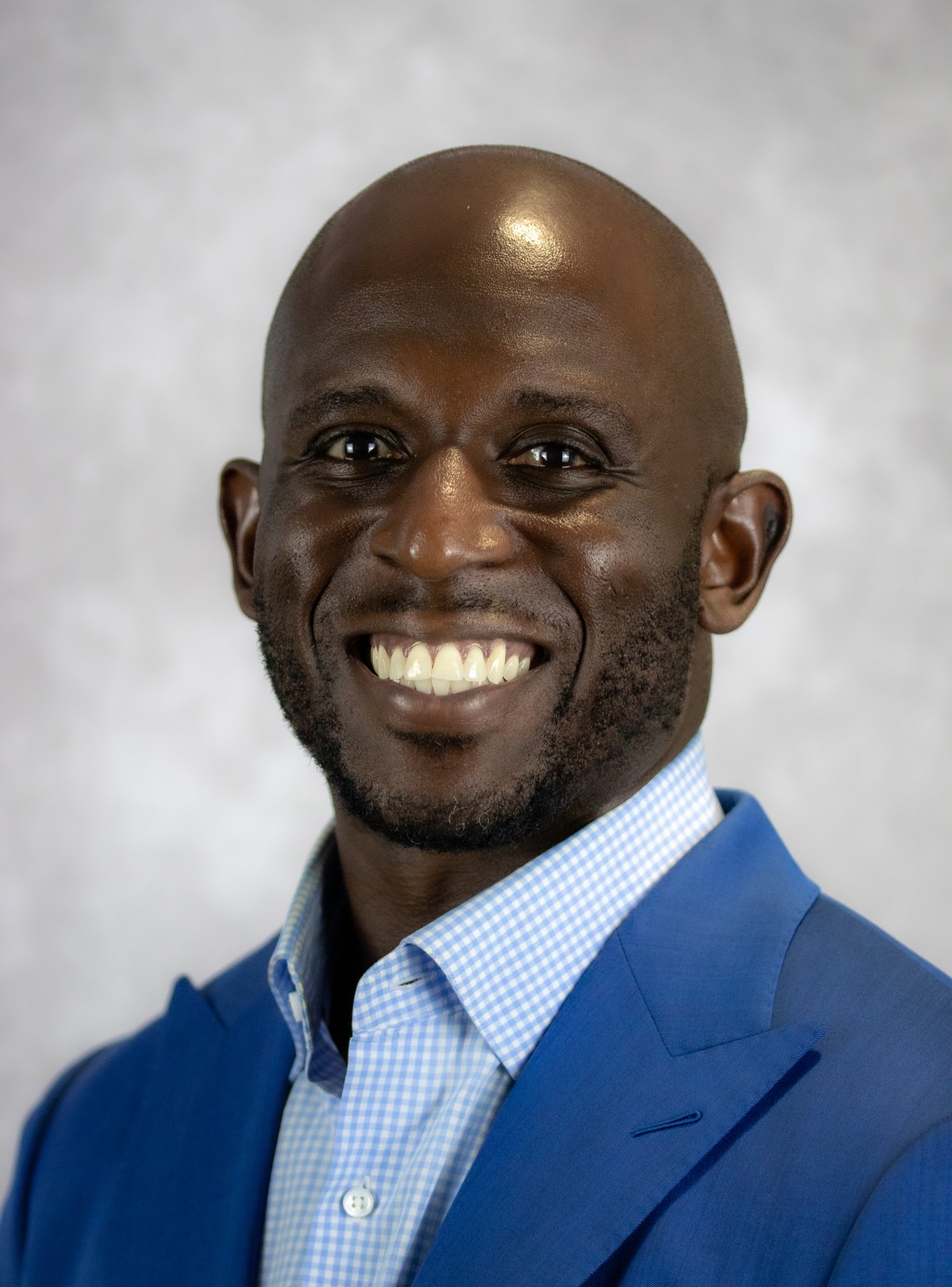 Executive headshot, blue blazer, studio backdrop