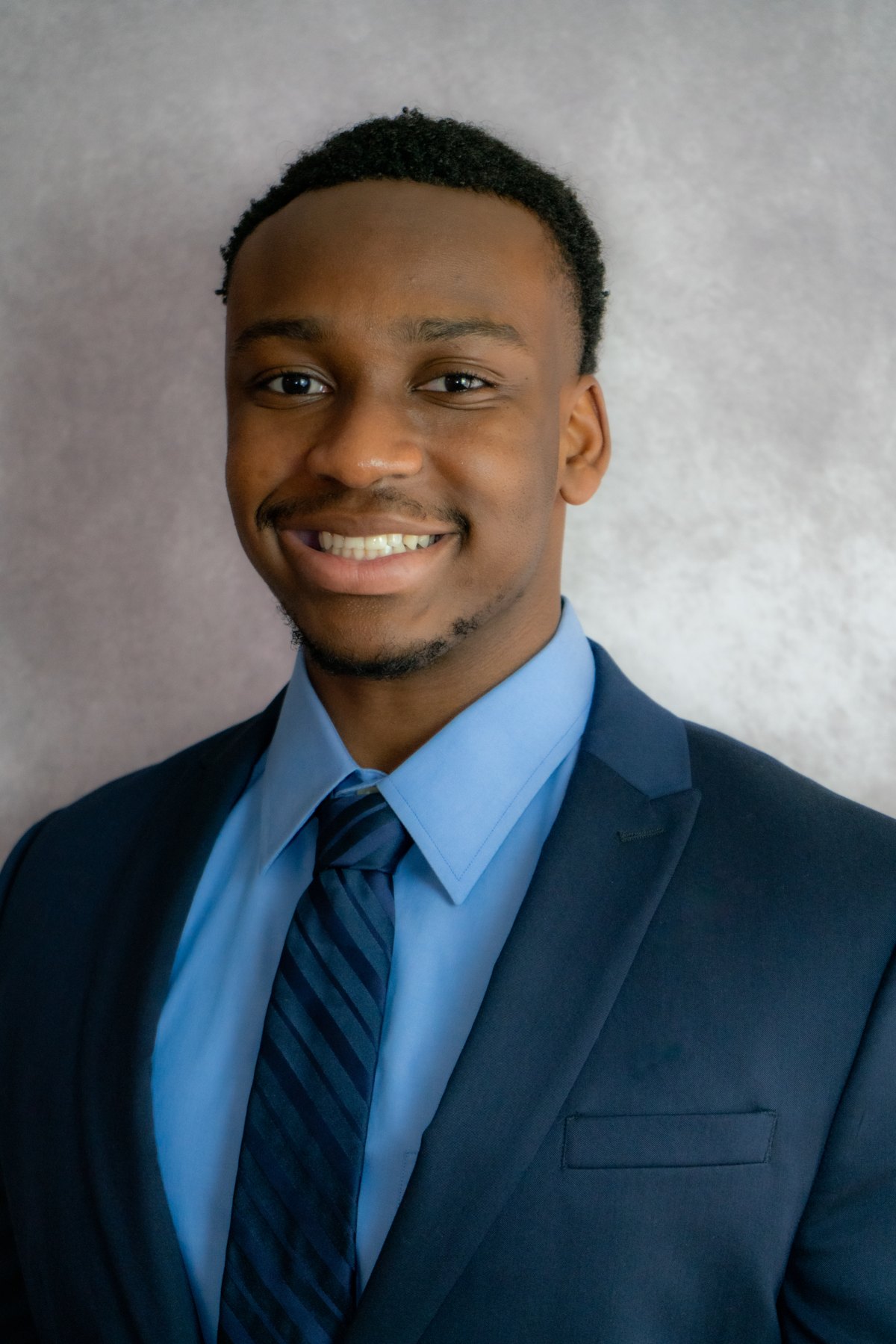 Professional headshot, grey suit, burgundy pocket square
